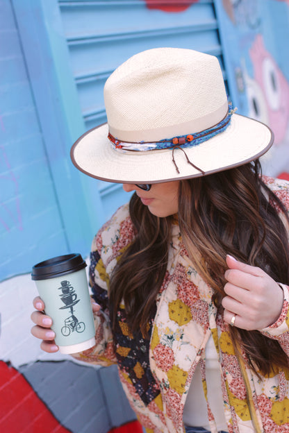 Natural Panama Fedora with leather piping on the brim. Silk Sari trim with leather cord. Left side view on Model. Three inch brim.