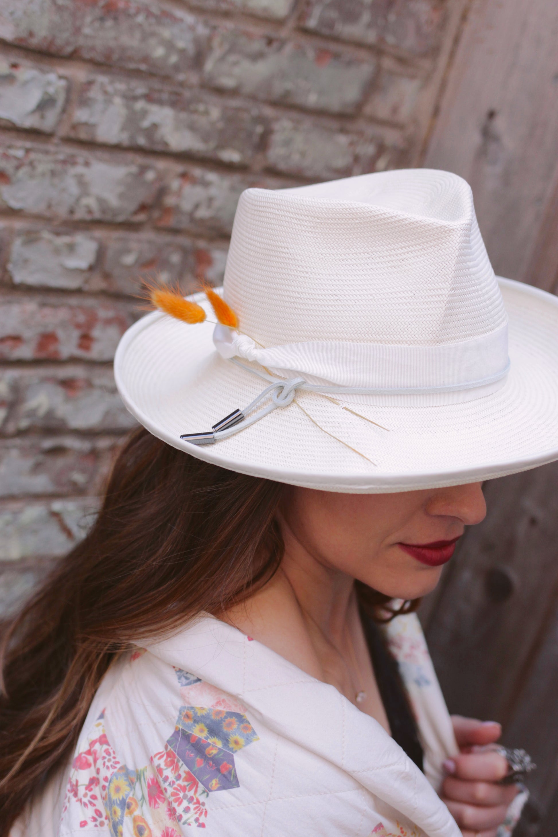 Ivory Straw fedora with 3" brim and a pleated crown. Trimmed with Ivory grosgrain ribbon with suede cord and bunny tails. Brim is piped with matching leather. Right side view