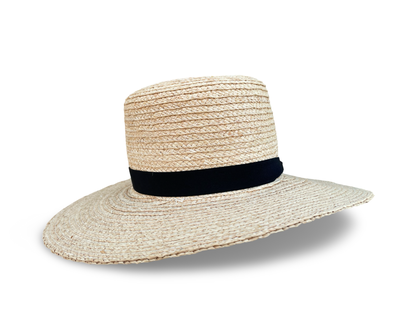 Front view of raffia straw packale travel hat with a black trim. 4" boater crown. Brim is 3" in the front and 4" on the left and right side. 