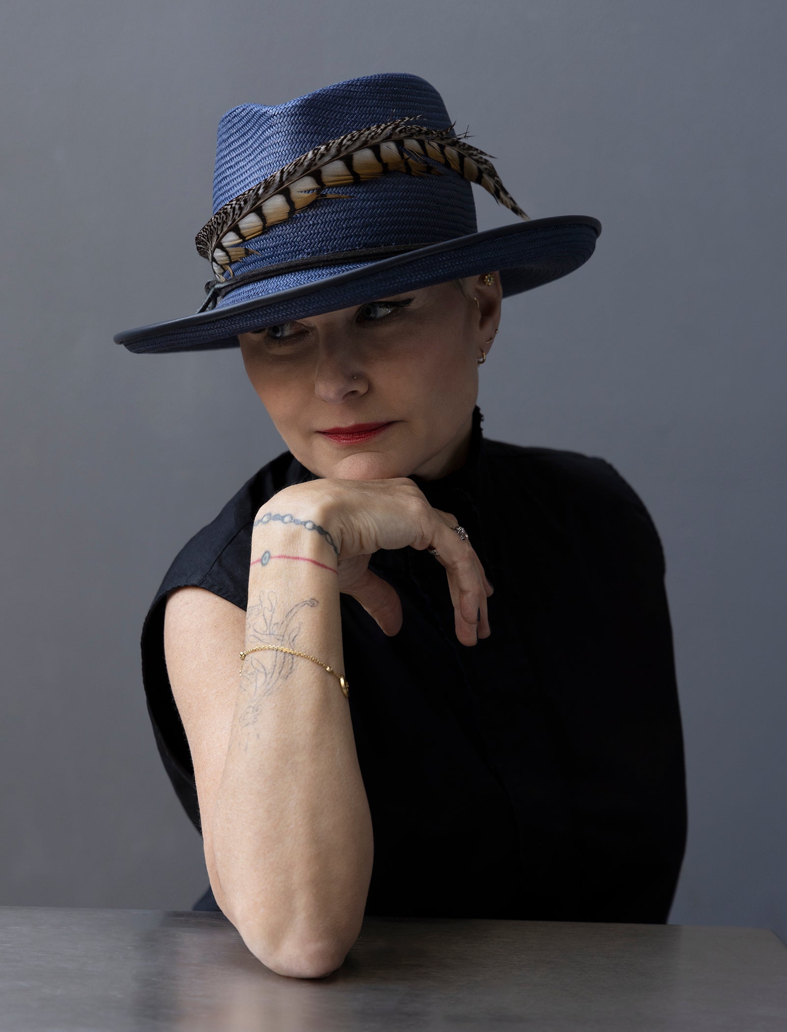 Navy Straw Fedora with upturned brim and pheasant tail trim. Brim is piping with navy lambskin.